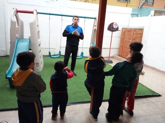 Niños participando en una actividad grupal en el patio de Happy Time
