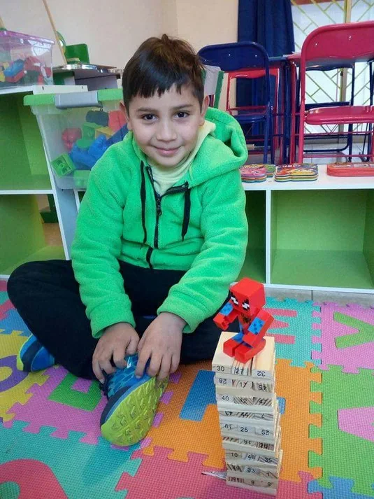 Niño sonriendo en un rincón de juegos de Happy Time After School en La Florida