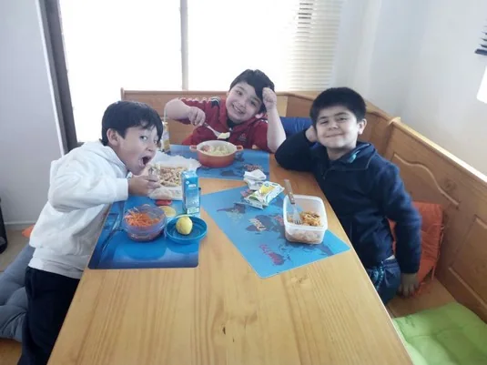 Niños compartiendo alrededor de una mesa de Happy Time After School en La Florida