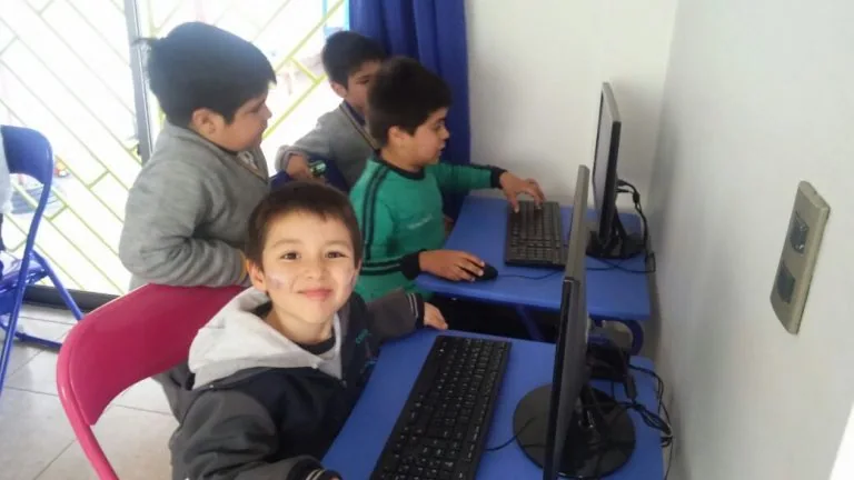 Niños usando computadores en Happy Time