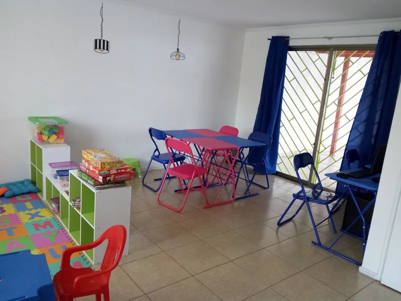 Sala de actividades con mesas, juegos y materiales