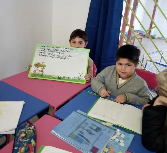 Niño mostrando su trabajo en Happy Time de Happy Time After School en La Florida
